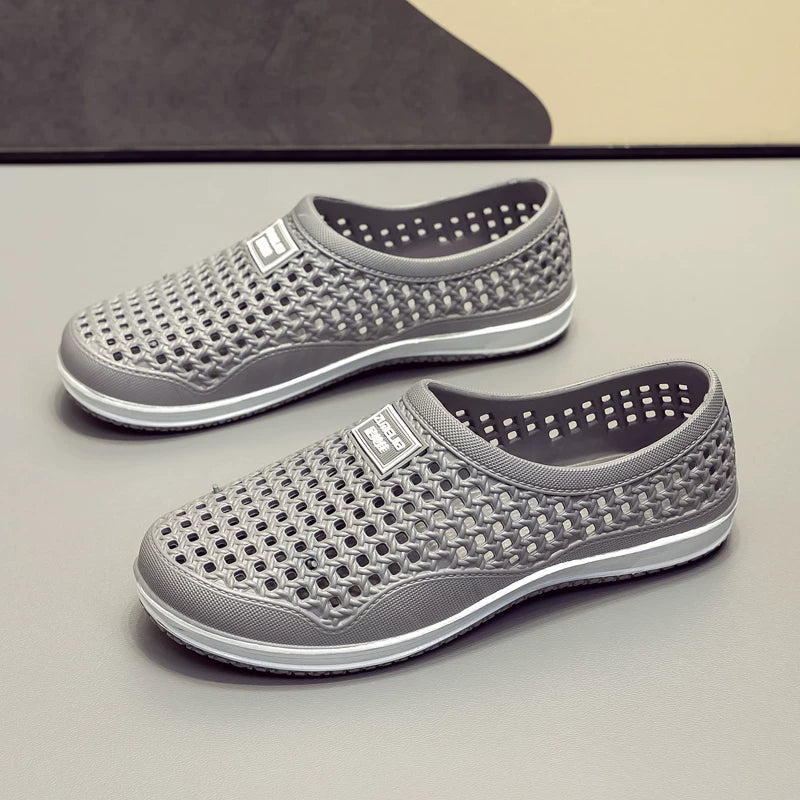 Harmaa rei'itetty slip-on loaferi pari edestä tasaisella alustalla — Helvenza