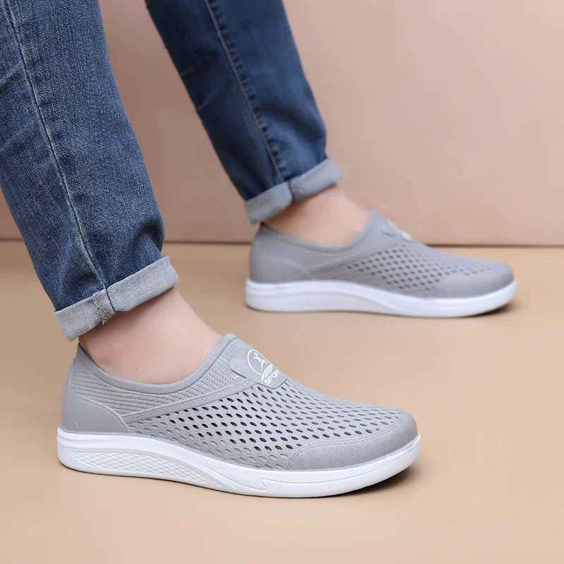 Harmaat reikäkuvioiset slip-on-tennarit sivulta, valkoinen pohja — Helvenza