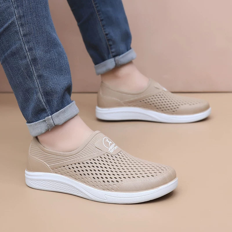 Beige reikäkuvioiset slip-on-tennarit sivulta, valkoinen pohja — Helvenza