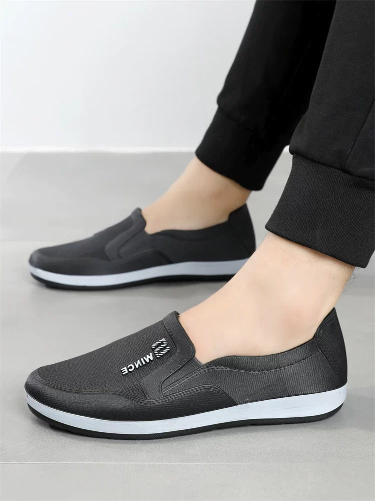 Mustat slip-on tennarit jalassa mustat housut — Helvenza