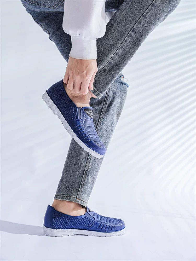 Siniset slip-on loaferit jalassa seisoma-asennossa valkoisella pohjalla — Helvenza