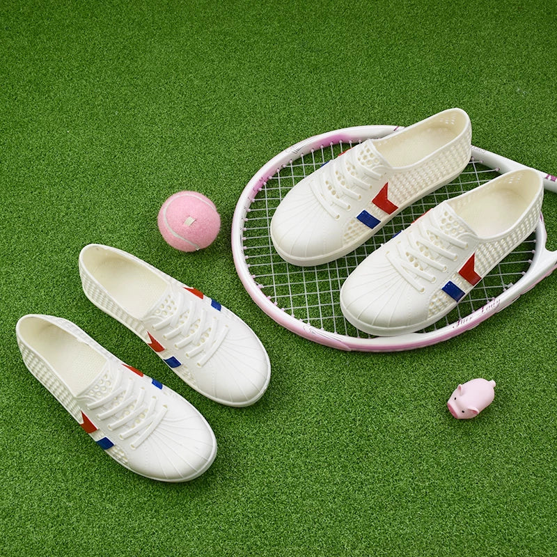 Valkoiset rei'itetyt tenniskengät pari ylhäältä tennismailan ja pallon kanssa — Helvenza
