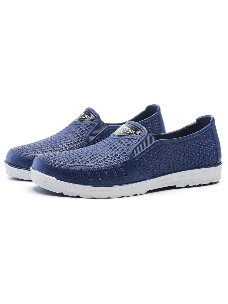 Siniset slip-on loaferit jalassa seisoma-asennossa valkoisella pohjalla — Helvenza