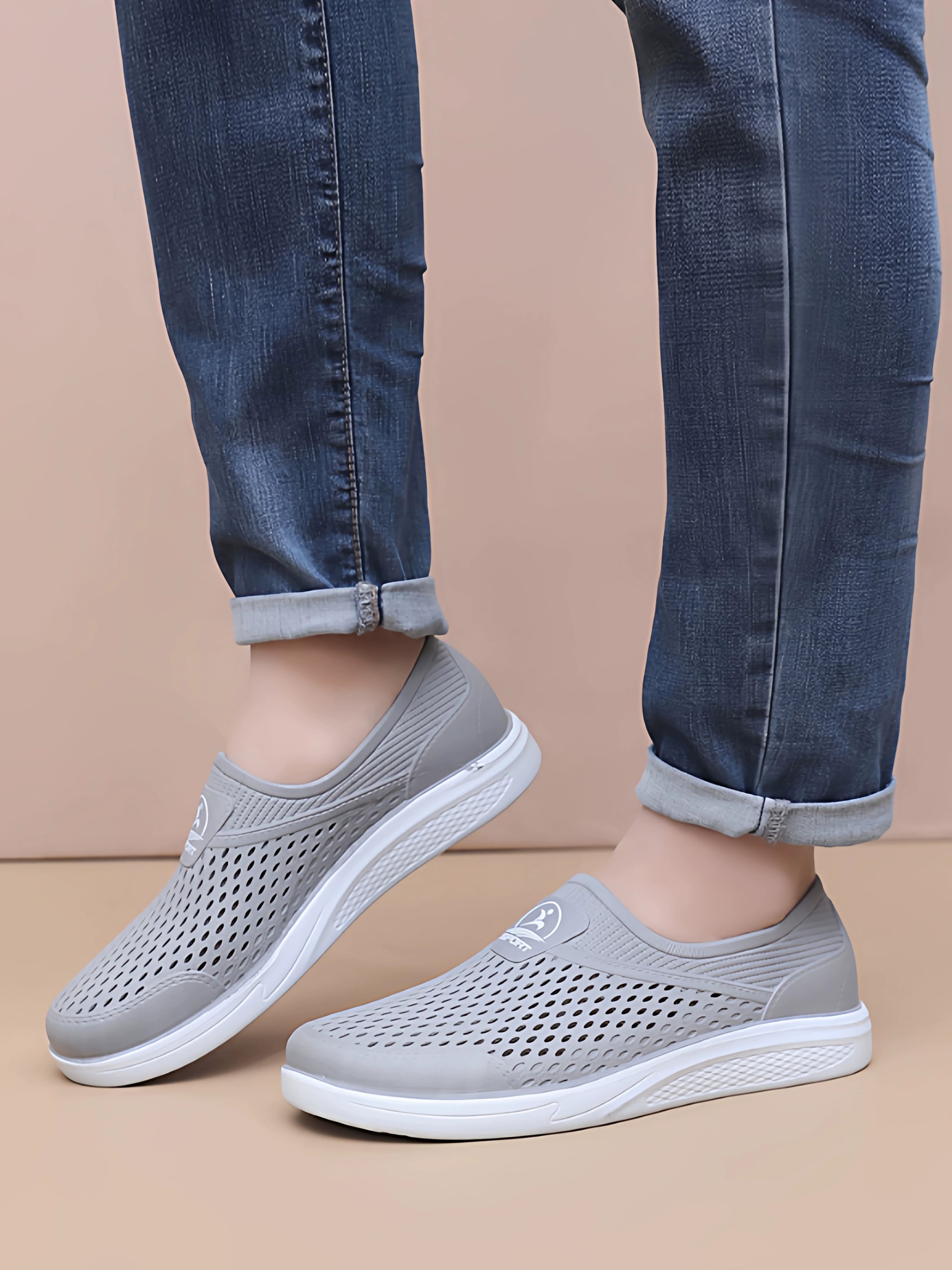 Harmaat slip-on-tennarit edestä jalkaan puettuna, valkoinen pohja — Helvenza