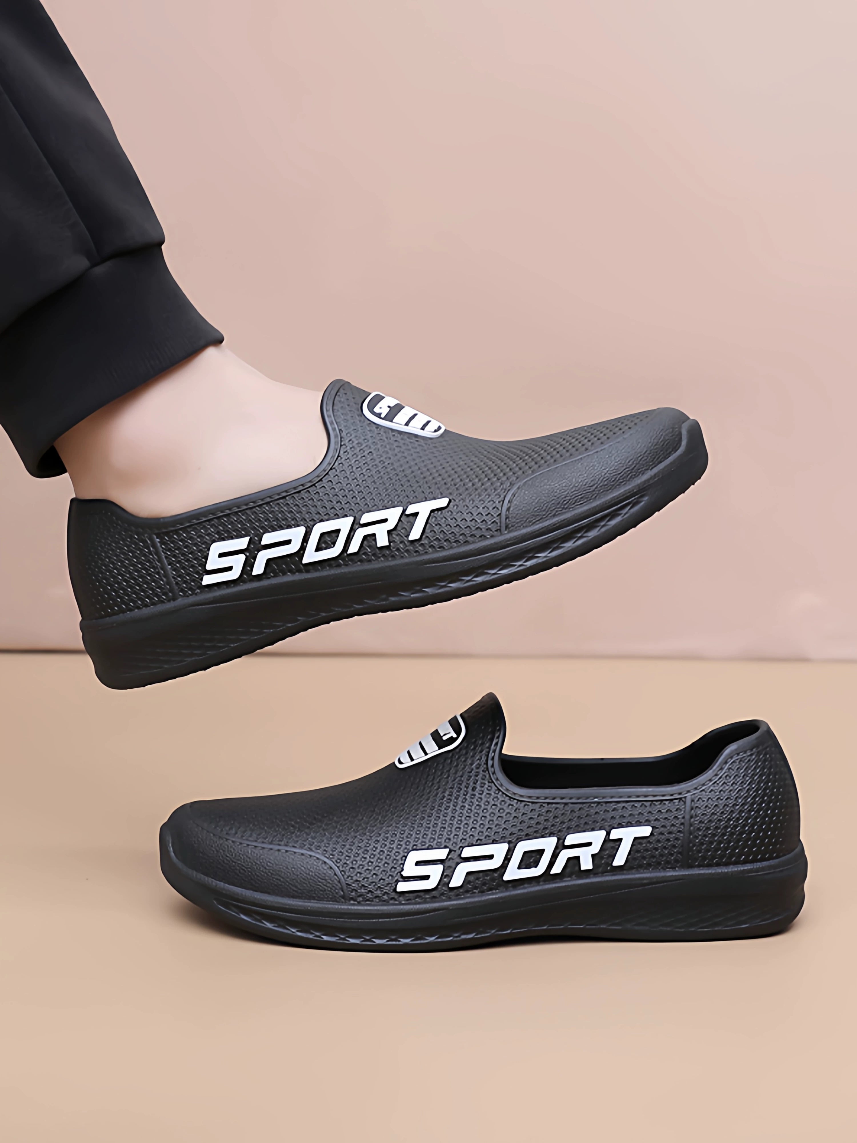 Musta slip-on lenkkarit sport-logolla jalassa sivulta — Helvenza