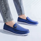 Siniset slip-on loaferit valkoisella pohjalla päällä farkkujen kanssa — Helvenza