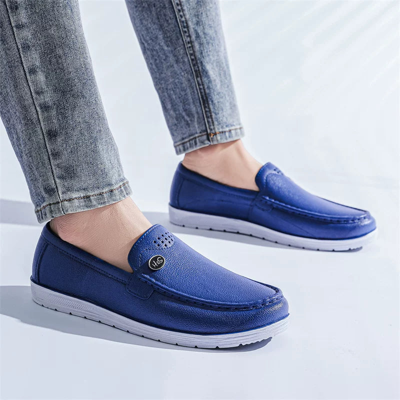 Siniset slip-on loaferit valkoisella pohjalla päällä farkkujen kanssa — Helvenza