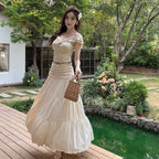 Beige röyhelösetti kokonaan edestä puutarha- ja vesiallastaustalla — Helvenza