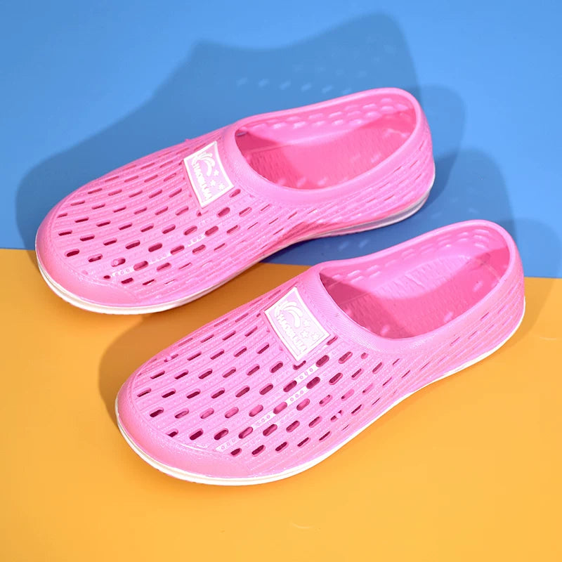 Vaaleanpunainen reikäkuvioinen slip-on-tossu edestä valkoisella pohjalla — Helvenza