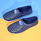 Laivastonsininen reikäkuvioinen slip-on-tossu sivulta valkoisella pohjalla — Helvenza