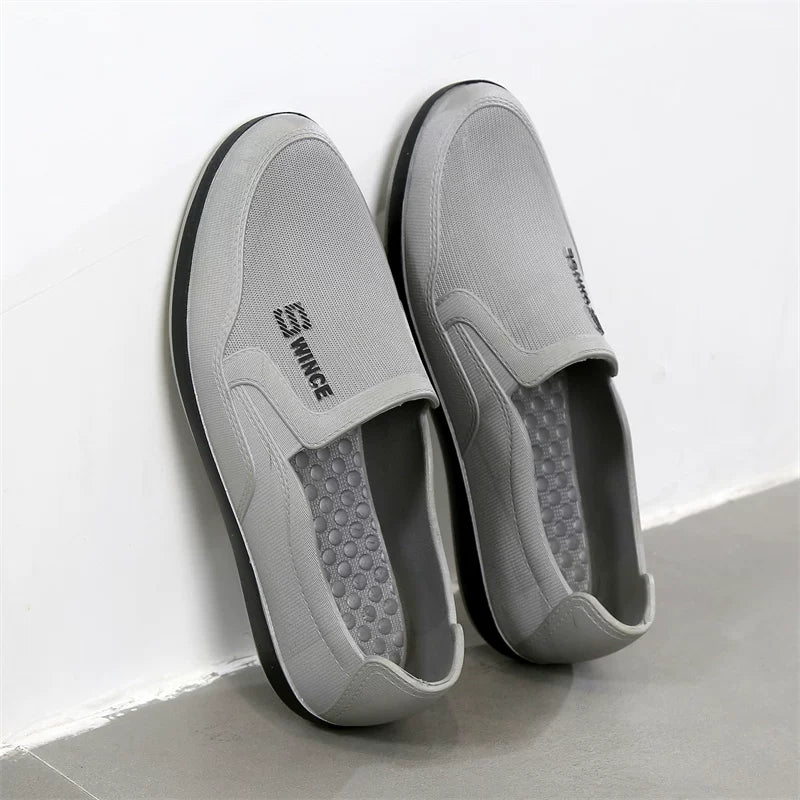 Harmaat slip-on tennarit pari sivulta mustalla pohjalla — Helvenza
