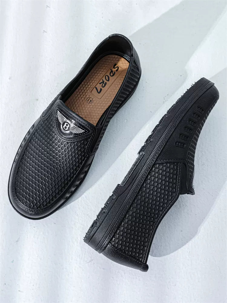 Mustat slip-on loaferit kohopistekoristelulla päällisellä ylhäältä ja sivulta — Helvenza
